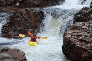 A person in a kayak in a river Description automatically generated with low confidence