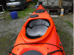 A picture containing grass, outdoor, orange, transportDescription automatically generated