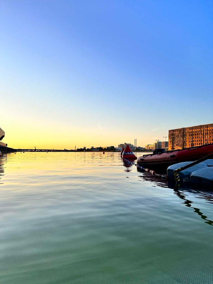 A body of water with boats in it and buildings in the backgroundDescription automatically generated with medium confidence