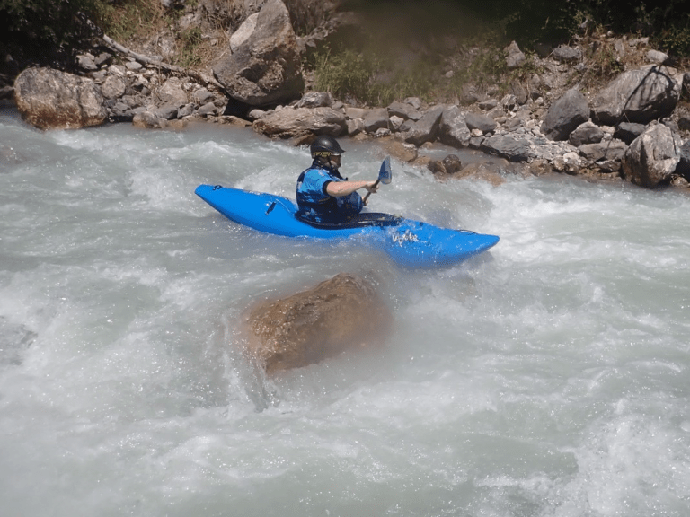 A person in a kayak in a river Description automatically generated with low confidence