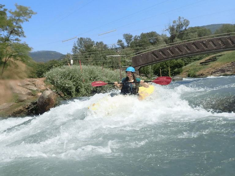 A person in a kayak in a river Description automatically generated with low confidence