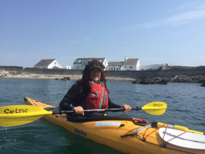 A person in a yellow kayak Description automatically generated with medium confidence
