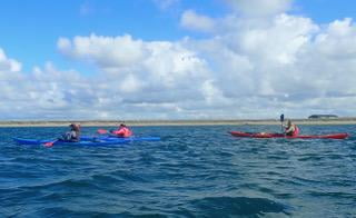 A group of people in kayaks on the waterDescription automatically generated with low confidence