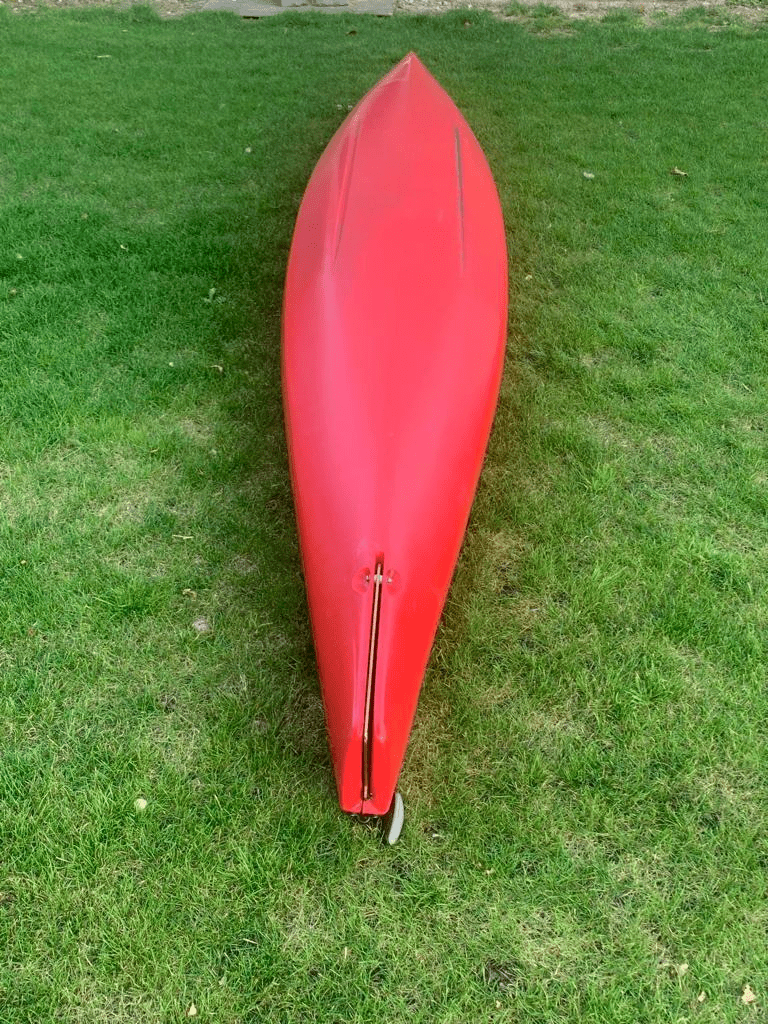 A red umbrella on the grassDescription automatically generated with medium confidence