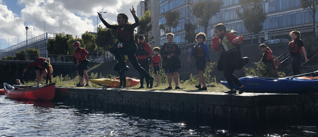 A group of people jumping into waterDescription automatically generated with medium confidence