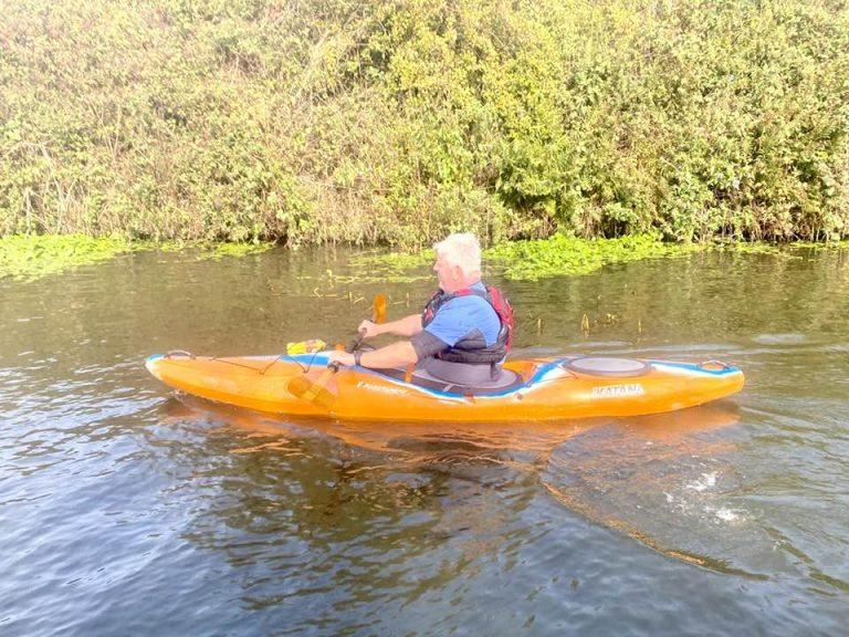 A person in a kayak on a river Description automatically generated with low confidence
