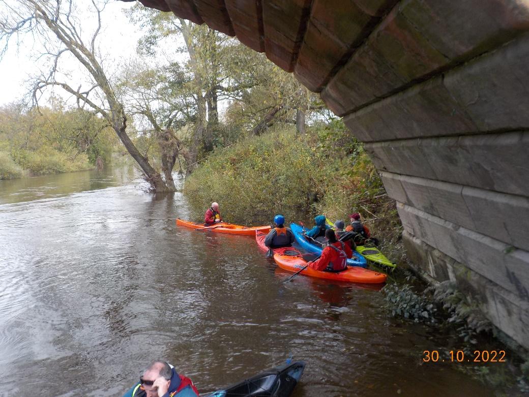 A group of people in kayaks on a riverDescription automatically generated with medium confidence