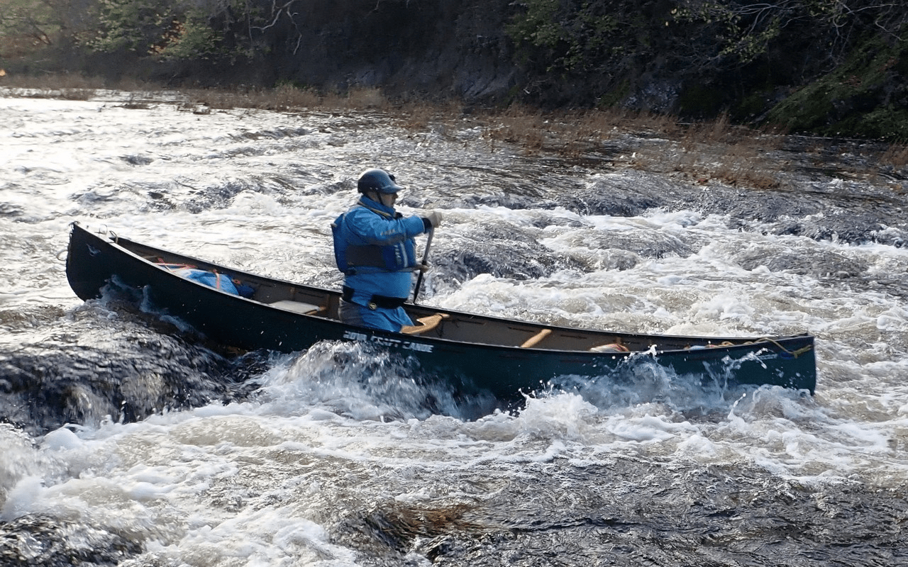 A person in a boat on a riverDescription automatically generated with low confidence