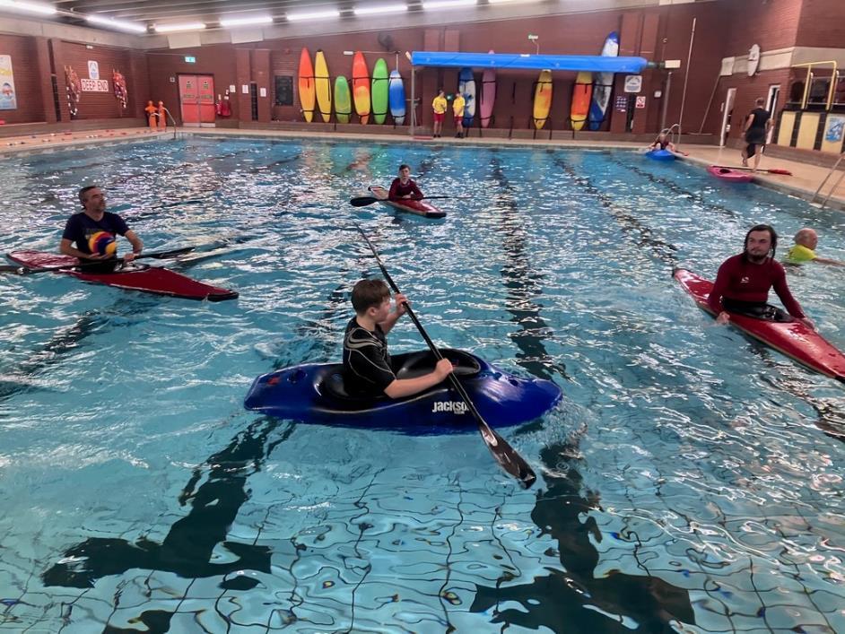 A group of people in kayaks in a poolDescription automatically generated with low confidence