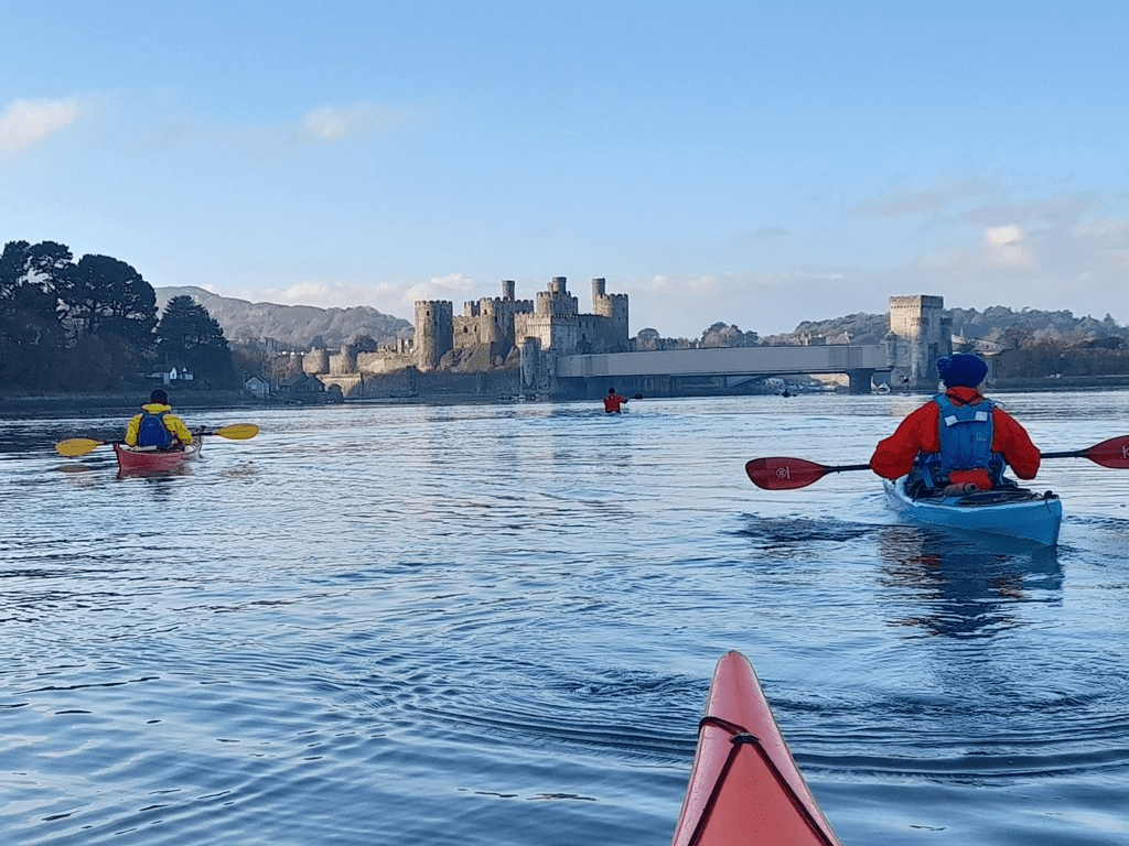A group of people in kayaks on a lakeDescription automatically generated with low confidence