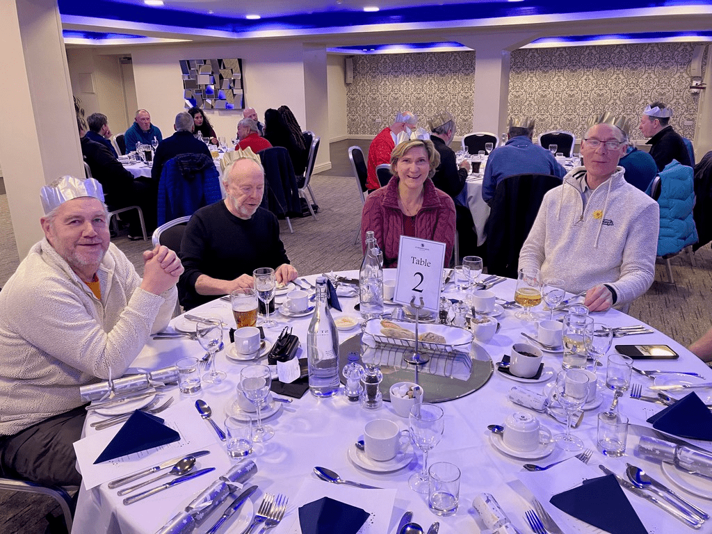 A group of people sitting at a tableDescription automatically generated with low confidence
