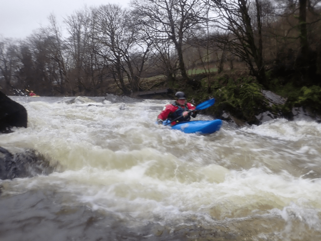 A person in a kayak in a riverDescription automatically generated with medium confidence