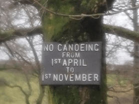 A sign on a treeDescription automatically generated with medium confidence