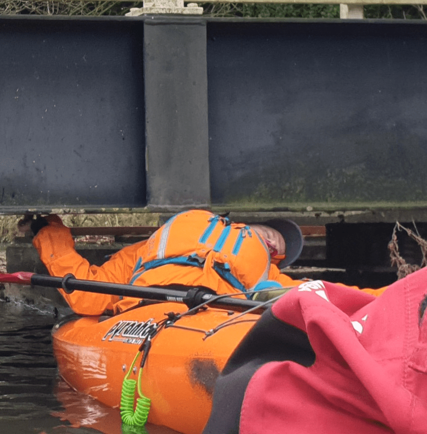 A person in a life jacket in a body of waterDescription automatically generated with low confidence