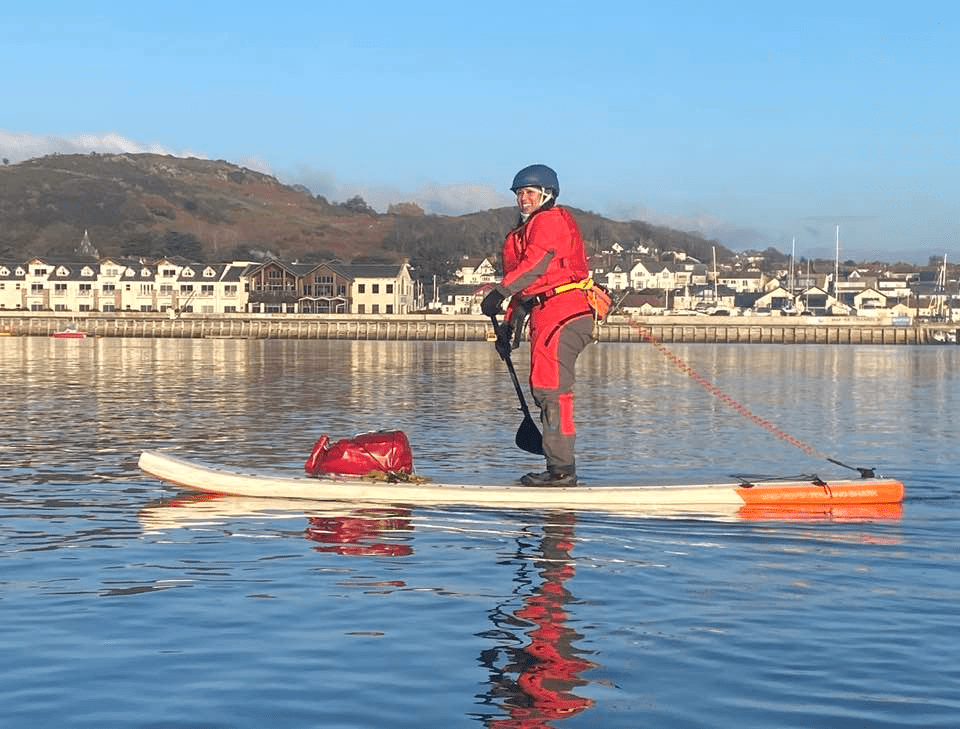 A picture containing water, outdoor, red, ridingDescription automatically generated