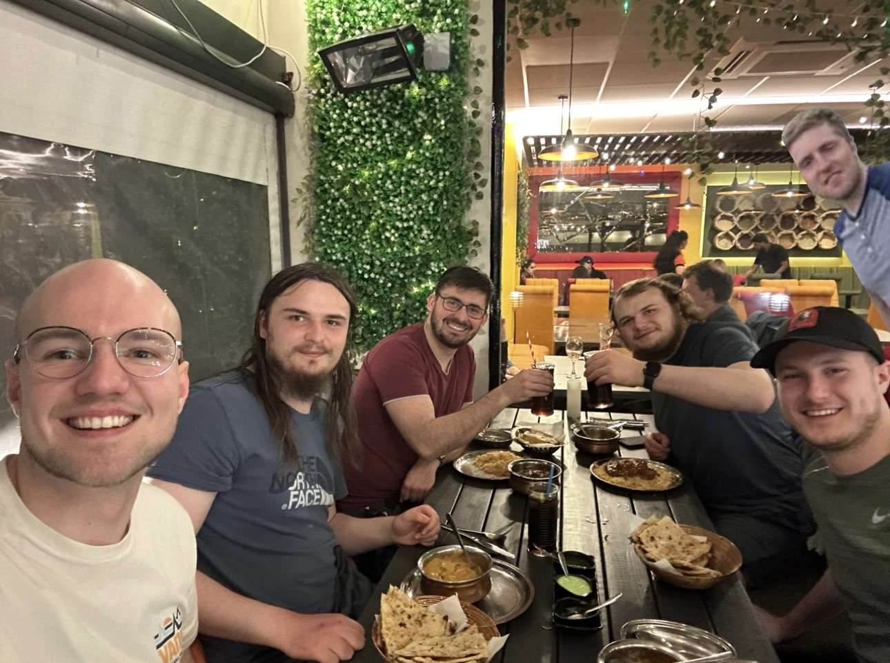 A group of people sitting at a table with foodDescription automatically generated with medium confidence