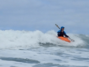 A person in a kayak in the ocean Description automatically generated with low confidence