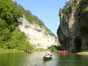 A group of people in canoes on a river Description automatically generated with low confidence