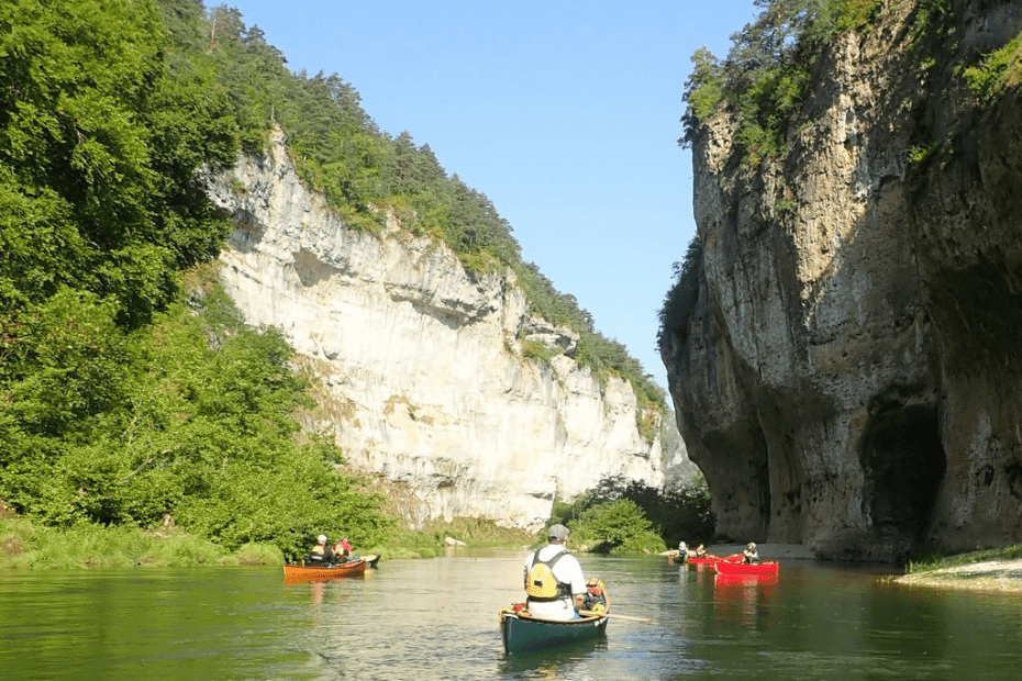 A group of people in canoes on a river Description automatically generated with low confidence