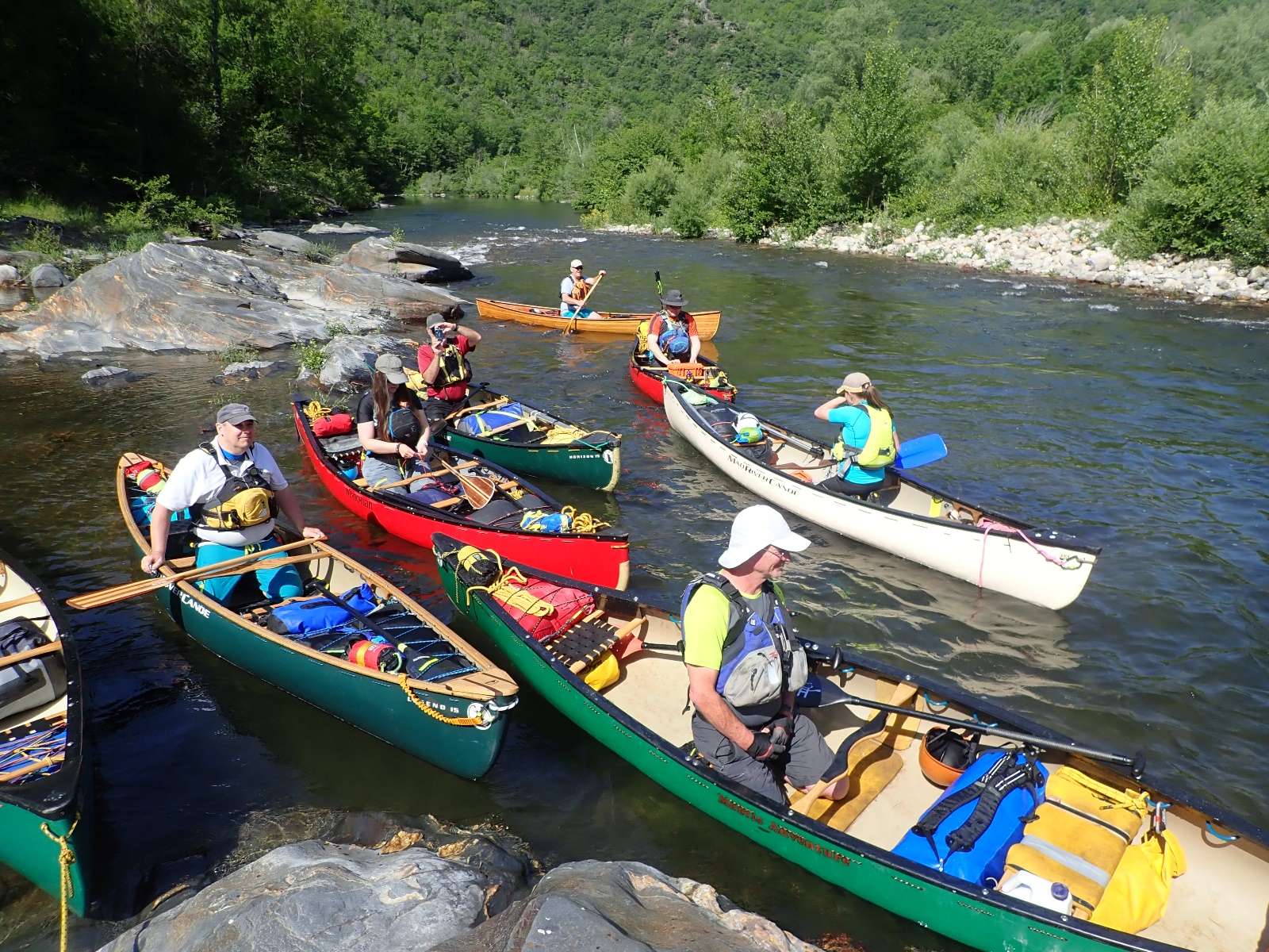 A group of people in canoes on a riverDescription automatically generated with medium confidence