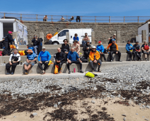 A group of people sitting on a ledge Description automatically generated