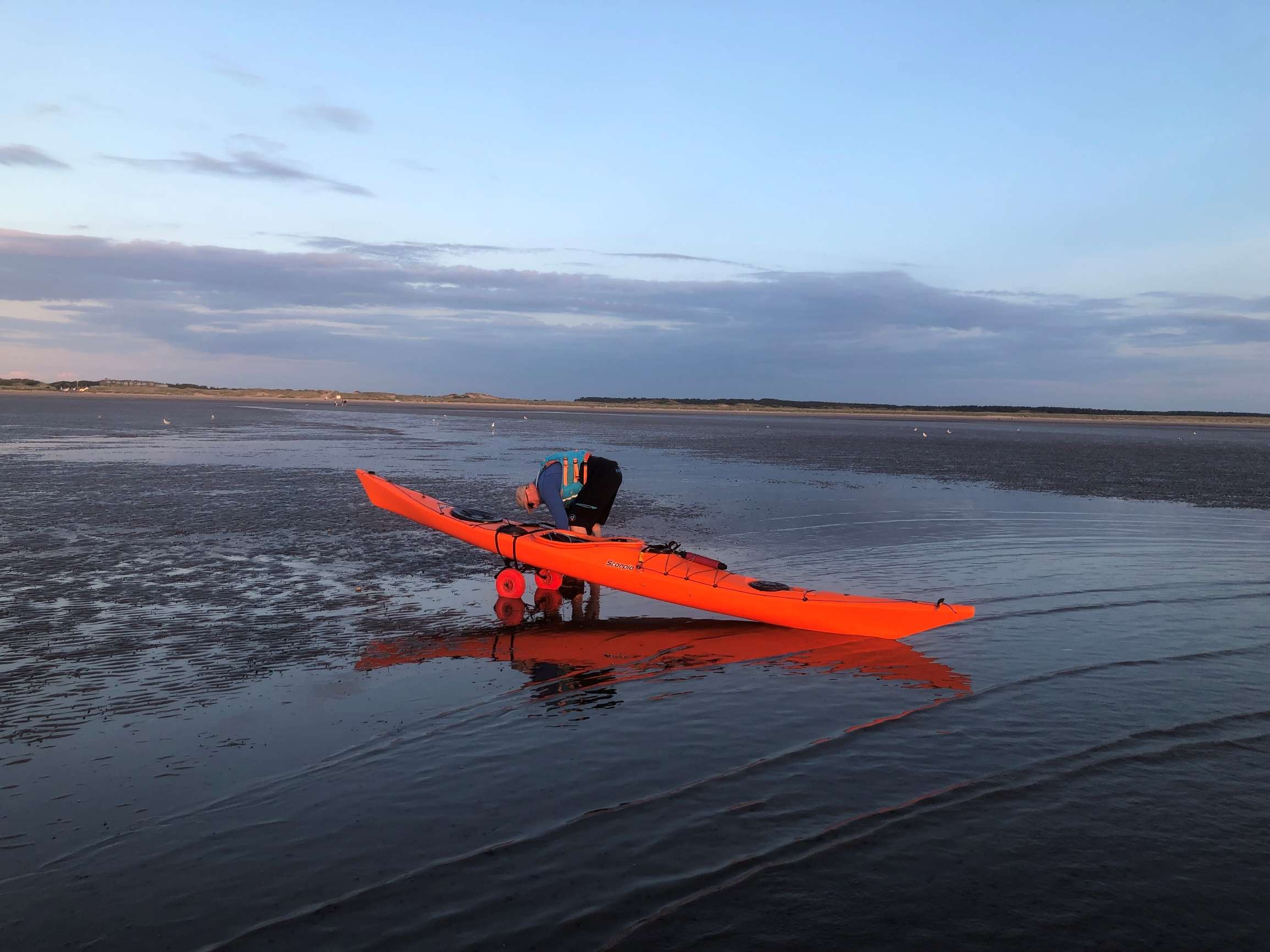 A person sitting in a kayak on a beachDescription automatically generated with low confidence