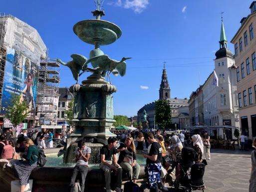 A group of people sitting around a fountainDescription automatically generated with medium confidence