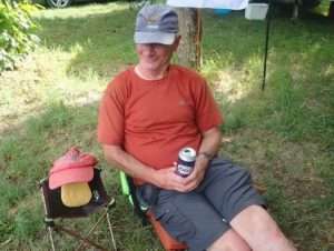 A person sitting in a chair with a can Description automatically generated with low confidence