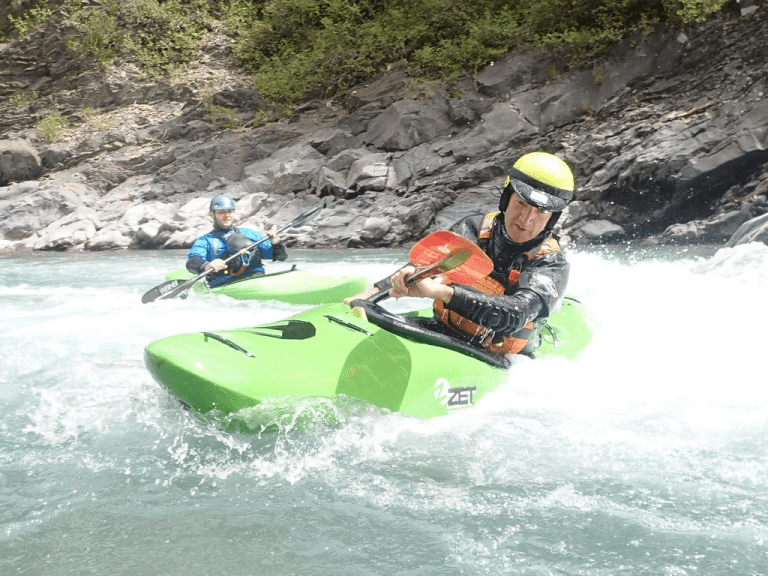 A group of people kayaking in a river Description automatically generated