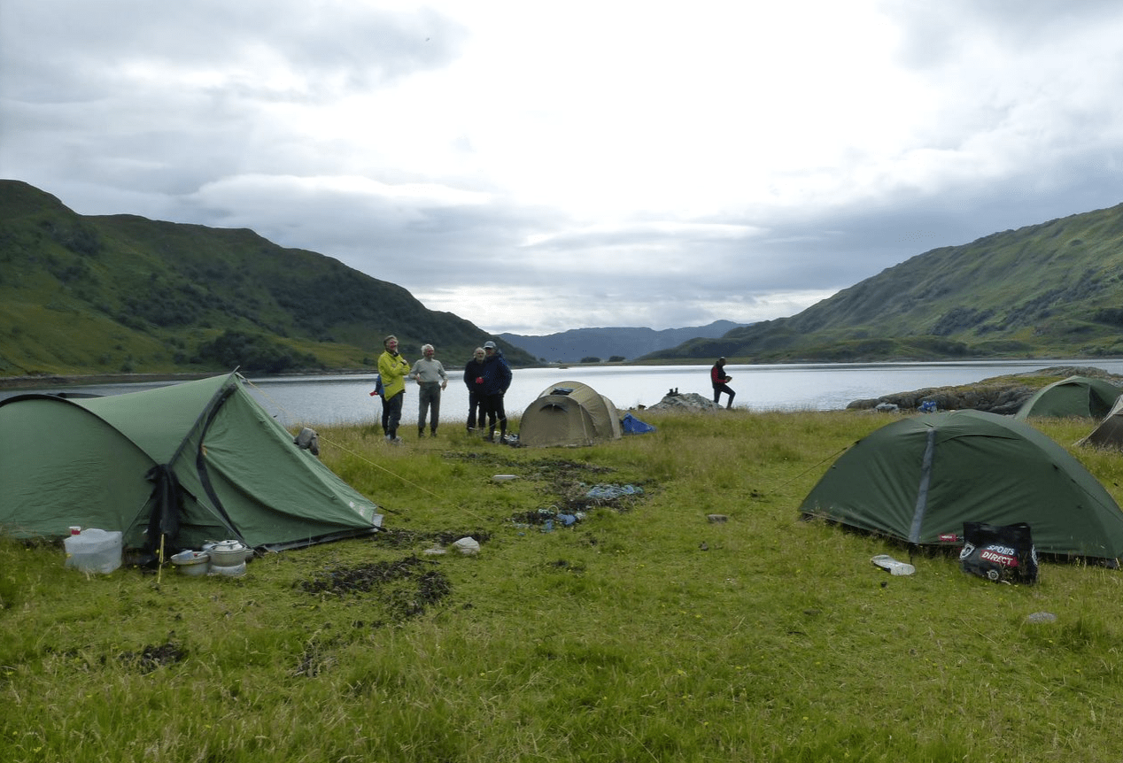 A group of people standing next to tentsDescription automatically generated
