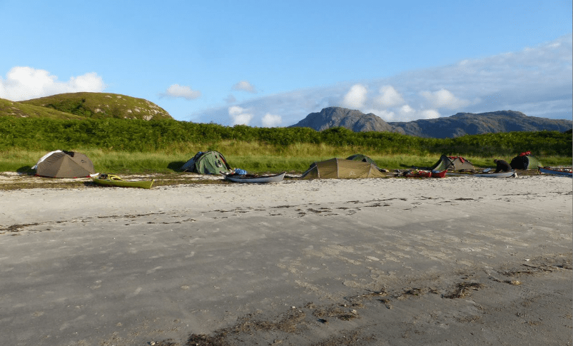 A group of tents on a beachDescription automatically generated