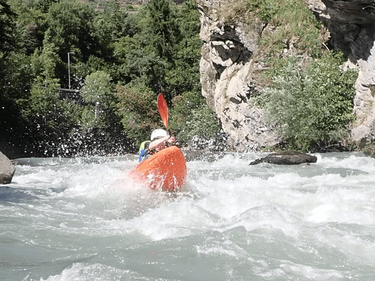 A person in a kayak in a riverDescription automatically generated