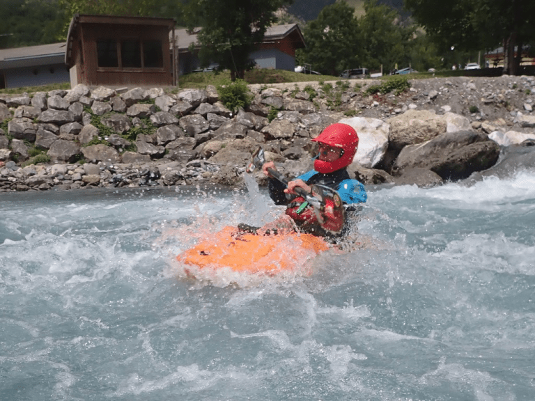 A person in a kayak in the water Description automatically generated