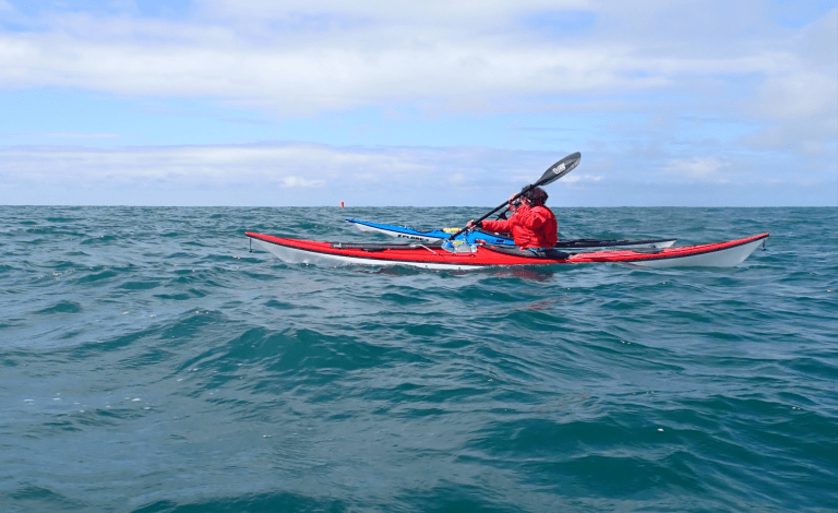 A person in a kayak on the water Description automatically generated