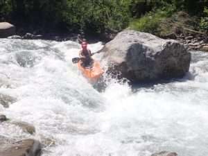 A person kayaking through a river Description automatically generated