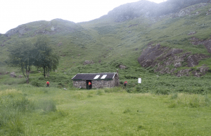 A stone building in a grassy area Description automatically generated