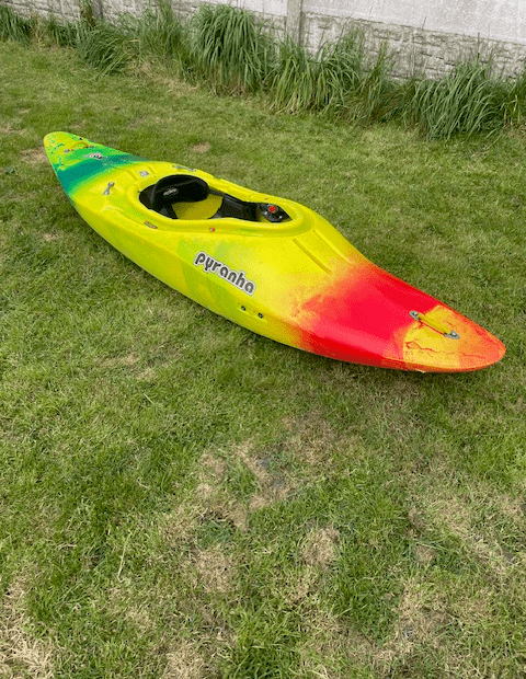 A colorful kayak on grass Description automatically generated