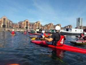 A group of people in kayaks on a river Description automatically generated