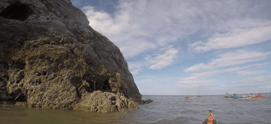 A large rock formation in the waterDescription automatically generated