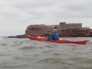 A person in a kayak on the water Description automatically generated
