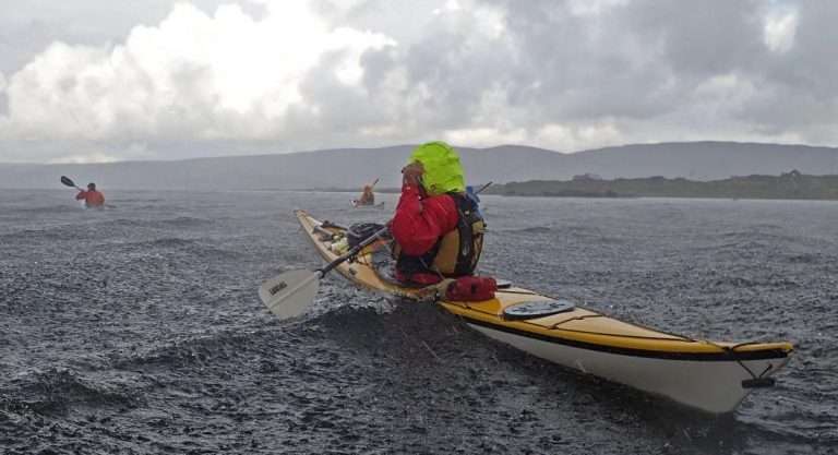 A person in a kayak on the water Description automatically generated