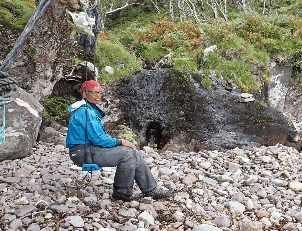 A person sitting on a rockDescription automatically generated