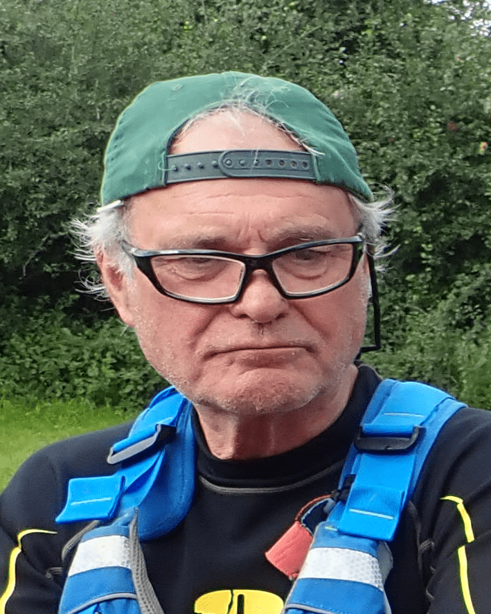 A person wearing a green hat and glassesDescription automatically generated