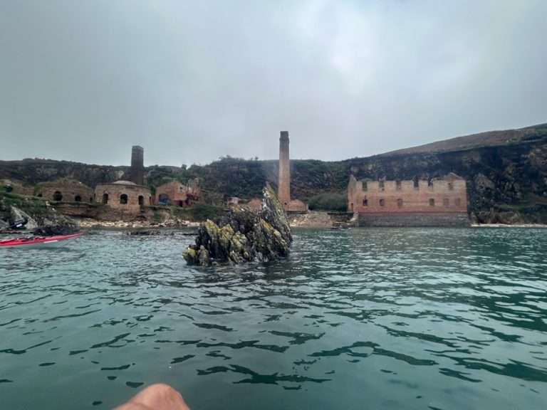 A body of water with buildings in the background Description automatically generated