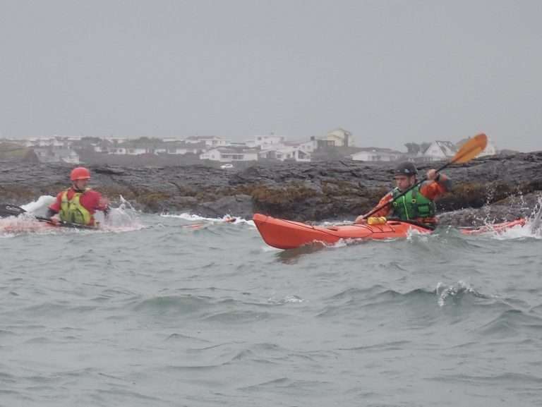 A group of people kayaking in the ocean Description automatically generated