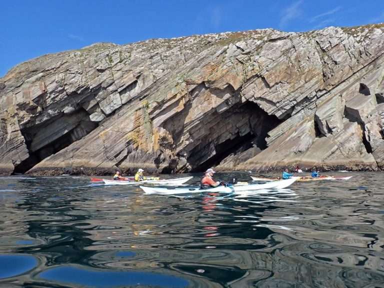 A group of people kayaking in the water Description automatically generated
