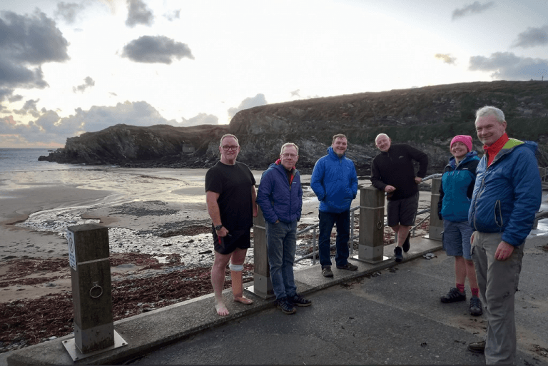 A group of people standing on a concrete wall Description automatically generated