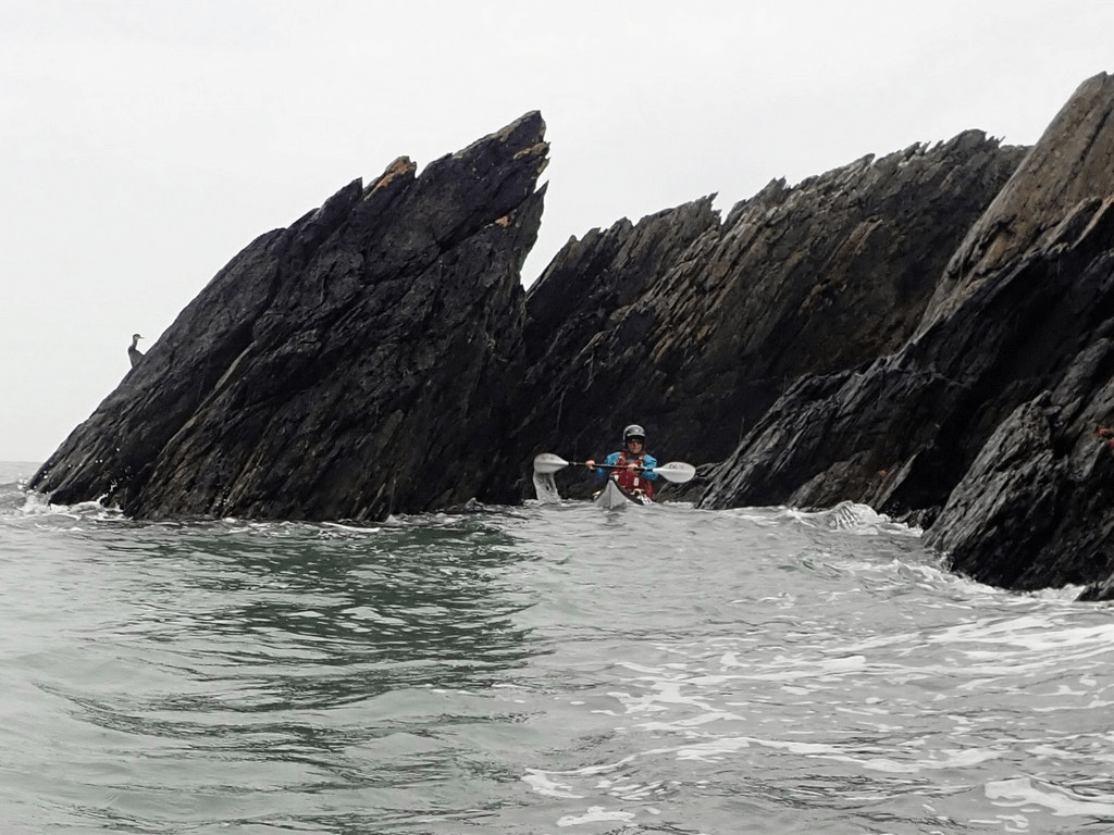 A person in a kayak in the waterDescription automatically generated