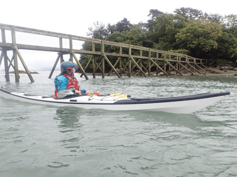 A person in a kayak on the water Description automatically generated