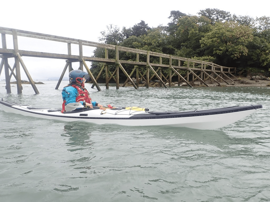 A person in a kayak on the waterDescription automatically generated